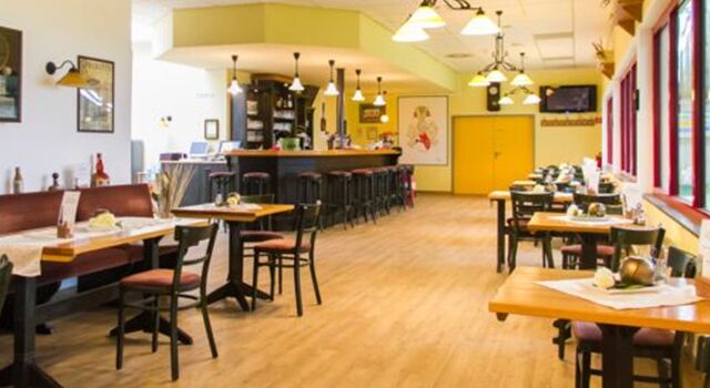 Leeres Restaurant mit Bar, Tischen und Stühlen auf Holzboden.