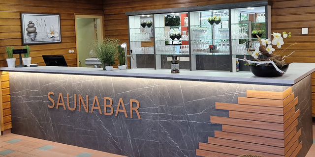 Moderne Saunabar mit Dekoration und Pflanzen im Empfangsbereich.