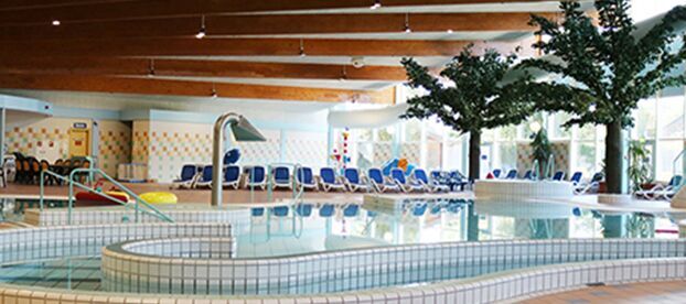Hallenbad mit Liegestühlen und Pflanzen