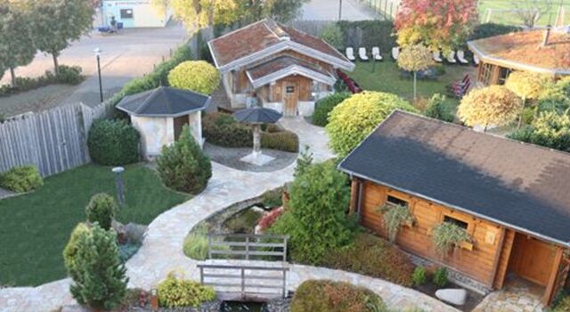 Luftbild eines Saunagartens mit Wegen, Saunas und Bäumen.