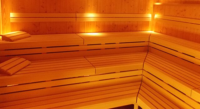 Holzsauna mit warmem Licht und Holzbänken, Innenansicht