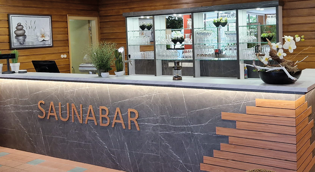 Moderne Saunabar mit Dekoration und Pflanzen im Empfangsbereich.